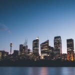 photo city beside body of water during sunset