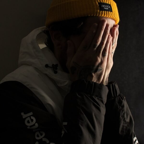 man covering his face with both hands